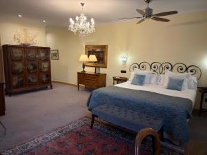 a bedroom with a large bed and a chandelier at Los Cinco Enebros Hotel & Spa by Bossh! Hotels in Robledo de Chavela +272 photos