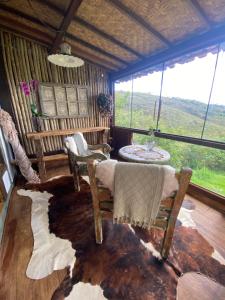 a living room with chairs and a large window at Chalés Vista das Montanhas in Lavras Novas +42 photos