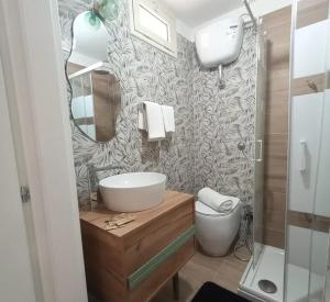 a bathroom with a sink and a toilet and a mirror at Irisapartment in Reggio di Calabria