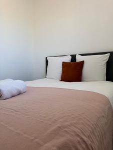 a bed with white and red pillows on it at Le Verger in Alixan