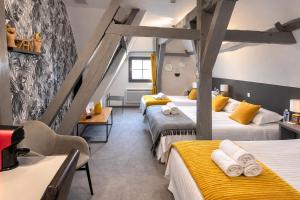 a room with three beds with yellow accents at The Originals Boutique, Hôtel Le George , Loches in Loches
