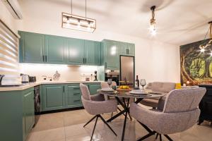 a kitchen with green cabinets and a table and chairs at Katherine's Village House in Ayios Ioannis