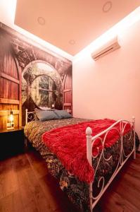 a bedroom with a bed with a red blanket on it at Katherine's Village House in Ayios Ioannis