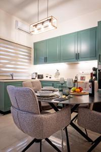 a kitchen with green cabinets and a table and chairs at Katherine's Village House in Ayios Ioannis