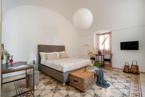 a bedroom with a bed and a table in a room at Dimora Sardaro Suites by BarbarHouse in Monopoli