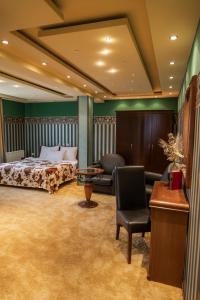 a bedroom with a bed and a chair and a table at Garni Hotel Garson-Lux NS in Novi Sad +125 photos