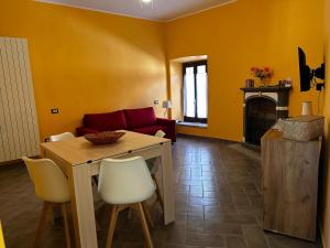 a living room with a table and a red couch at Casa Gio in Lesa