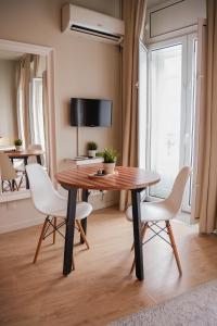 a dining room with a wooden table and white chairs at Impar Studios in Porto +85 photos
