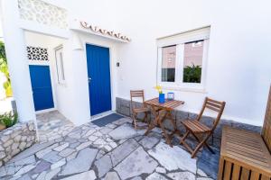 a patio with a table and chairs and a blue door at Brisa do Mar - Apartments in Lagos