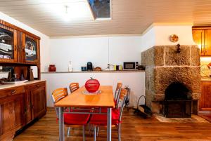 a kitchen with a table and a stone fireplace at Casa do Miradouro in Guarda