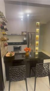 a kitchen with a counter with two chairs and a table at Casa Baviera -MOTO GP GOIANIA in Aparecida de Goiânia