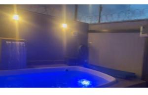 a bath tub in a bathroom with two lights at Casa Baviera -MOTO GP GOIANIA in Aparecida de Goiânia +4 photos
