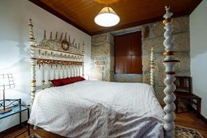 a bedroom with a white bed with a white comforter at Casa do Miradouro in Guarda