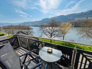 a table and chairs on a balcony with a view of a river at Hotel zum Anker in Detzem