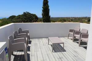 a group of chairs and tables on a balcony at Quinta dos Crastos Pool House in Porches +18 photos
