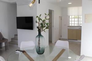 a vase with flowers sitting on a glass table in a room at Quinta dos Crastos Pool House in Porches