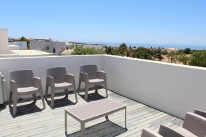 a row of chairs and a table on a balcony at Quinta dos Crastos Pool House in Porches
