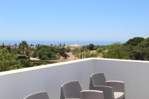 a group of white chairs sitting on top of a balcony at Quinta dos Crastos Pool House in Porches
