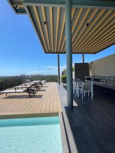 a deck with tables and chairs and a swimming pool at New 2 bedroom rooftop condo in Nuevo Vallarta