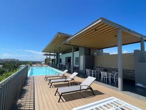 a deck with chairs and a swimming pool on a building at New 2 bedroom rooftop condo in Nuevo Vallarta