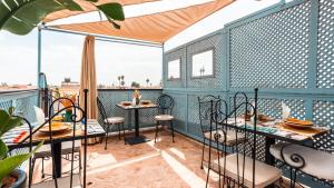eine Terrasse mit Tischen und Stühlen auf einem Balkon in der Unterkunft Riad Dama & Spa in Marrakesch