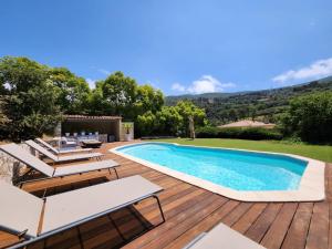 a villa with a swimming pool and a wooden deck at happyfew villa laghet in La Trinité