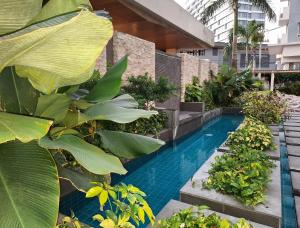 a swimming pool in the middle of a building with plants at Jade's Place Condo in Bacolod