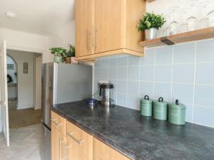 a kitchen with wooden cabinets and a refrigerator at Castle Gardens Apartment in Beaumaris +20 photos