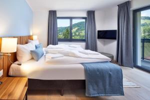 a bedroom with a large bed with a large window at Kristall Plaza in Niederau