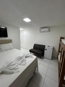 a hotel room with a bed and a chair at Pousada Avenida MELHOR CUSTO-BENEFÍCIO in Teixeira de Freitas