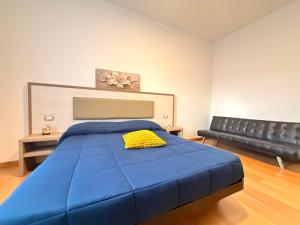 a bedroom with a blue bed and a couch at Luxury House Gallipoli in Gallipoli