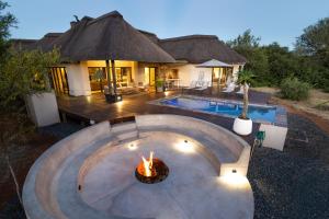 a backyard with a fire pit in front of a house at Villa Blaaskans in Hoedspruit