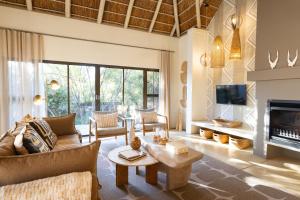 a living room with a couch and a fireplace at Villa Blaaskans in Hoedspruit