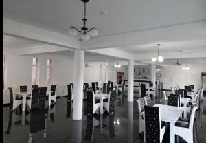 a dining room with white tables and chairs at Red House in Orşova