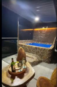 a room with a tub with a table with two bottles of wine at Hotel Las Piedras San Jose in San José de Isnos