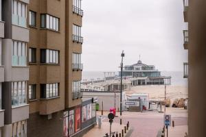 a view of a beach and a building with a pier at Casiola - Spacious apartment with private car park in Blankenberge
