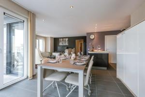 a dining room and kitchen with a table and chairs at Casiola - Spacious apartment with private car park in Blankenberge +13 photos