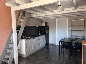 a kitchen with a staircase leading up to a loft at Biscalove in Biscarrosse
