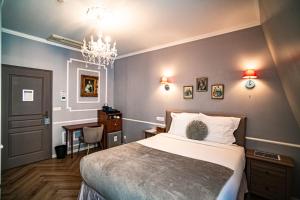a bedroom with a bed and a table and a chandelier at La Maison Gobert Paris Hotel Particulier in Paris +174 photos