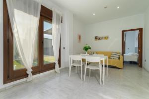 a living room with a table and chairs and a couch at Áticos Lux Sevilla Piscina Parking in Bormujos +93 photos