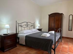 a bedroom with a large bed and a wooden cabinet at Locanda Del Castello Bed an Breakfast in San Panfilo dʼOcre