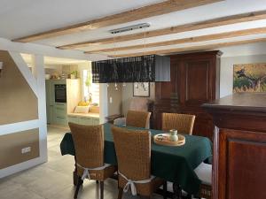 a kitchen and dining room with a green table and chairs at Cora in Pruchten
