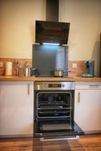 a kitchen with an oven with pots and pans at Fleur des Vents in Saint-Flour +16 photos
