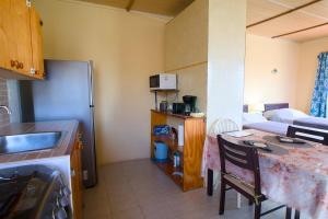 a kitchen with a sink and a table in a room at Esaw Place in Christ Church