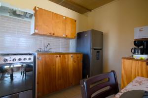 a kitchen with wooden cabinets and a refrigerator at Esaw Place in Christ Church +28 photos