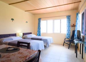 a hotel room with two beds and a tv at Esaw Place in Christ Church