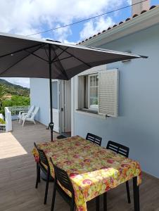 a patio with a table and an umbrella at Casa Azul (Blue House) in Urzelina