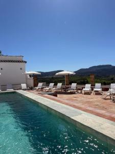 a swimming pool with lounge chairs and a house at Galteo Almendra - Pool in Ronda