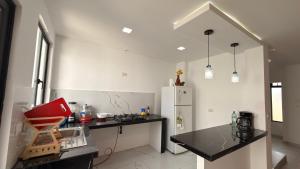 a kitchen with a black counter and a refrigerator at Casa moderna, amplia y acogedora Valentina in Loja +26 photos