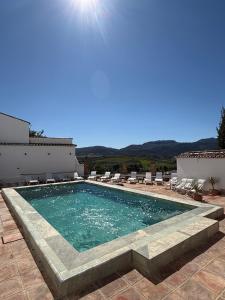 a swimming pool with chairs on a patio at Galteo Almendra - Pool in Ronda